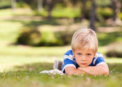 Boy lying down in the park during the summer 