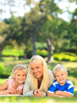 Mother with her children lying down in the park during the summer