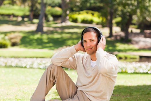 Man listening to music during the summer in the park