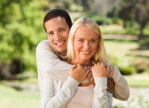 Woman hugging her boyfriend in the park during the summer 