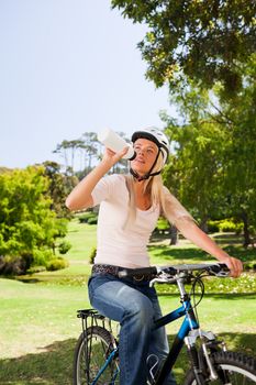 Woman in the park with her bike during the summer in a park