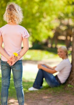 Daughter offering a flower to her mother during the summer 