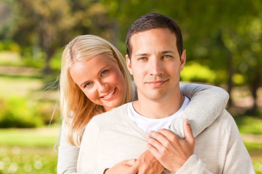 Woman hugging her boyfriend in the park during the summer 