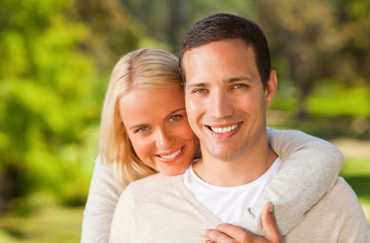 Woman hugging her boyfriend during the summer in the park