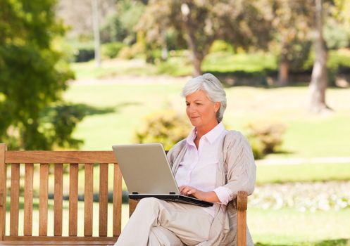 Retired woman working on her laptop during the summer 