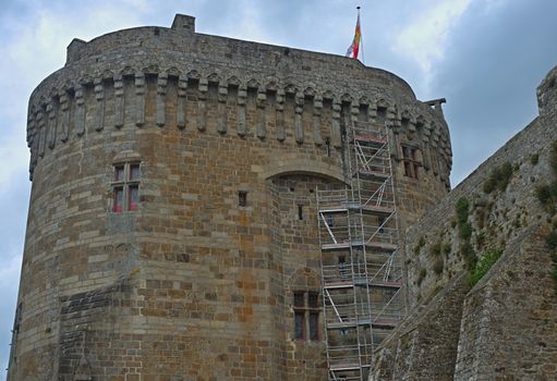 Big central stone tower with flag on top at Dinan fortress, France