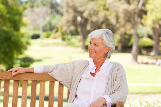 Senior woman on a bench during the summer in a park