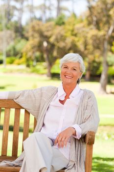 Senior woman on a bench in a park during the summer 