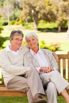 Senior couple on the bench in a park during the summer 