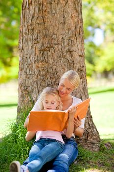 Daughter and her mother looking at their album photo during the summer 