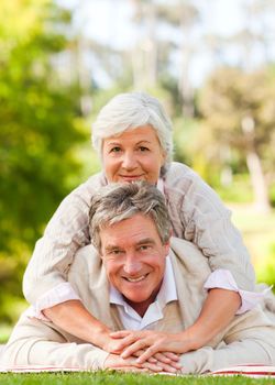 Mature couple lying down in the park during the summer