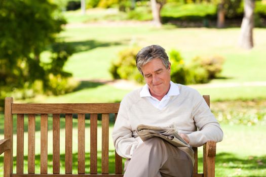 Man reading a newspaper during the summer