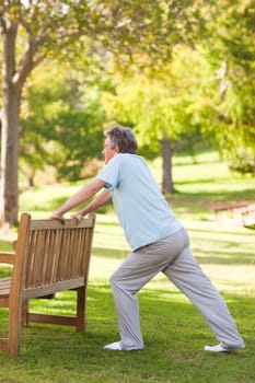 Retired man doing his stretches in the park during the summer