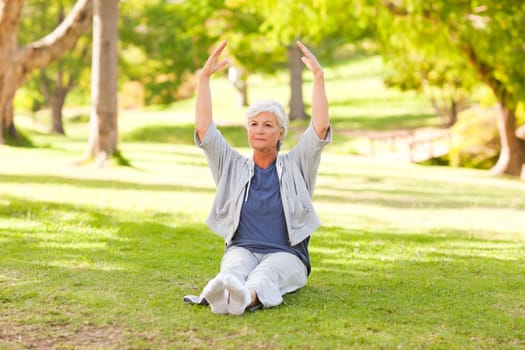 Senior woman doing her stretches in the park during the summer