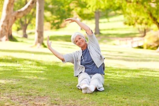 Senior woman doing her stretches in the park during the summer