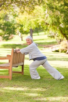 Senior woman doing her stretches in the park during the summer