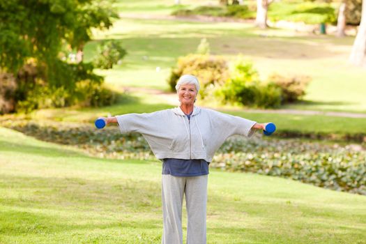 Mature woman doing her exercises in the park during the summer