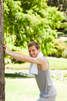 Man doing his stretches in the park during the summer