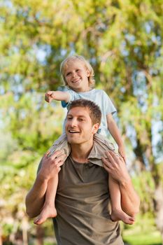 Happy father giving son a piggyback during the summer