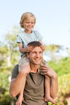 Father giving son a piggyback during the summer