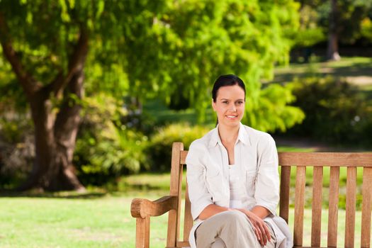 Brunette woman on the bench during the summer