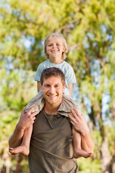 Happy father giving son a piggyback during the summer