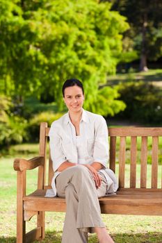 Brunette woman on the bench during the summer