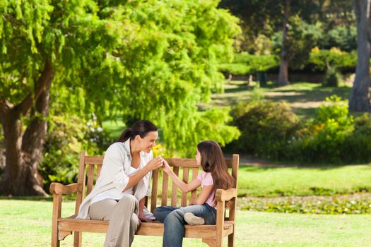 Cute girl with her mother in the park during the summer