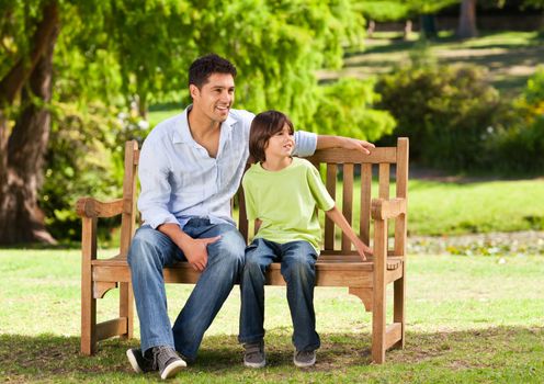 Father with his son on the bench during the summer