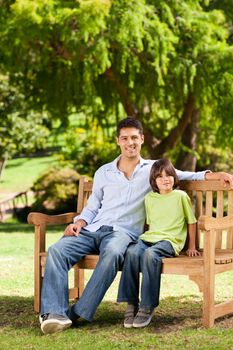 Father with his son on the bench during the summer