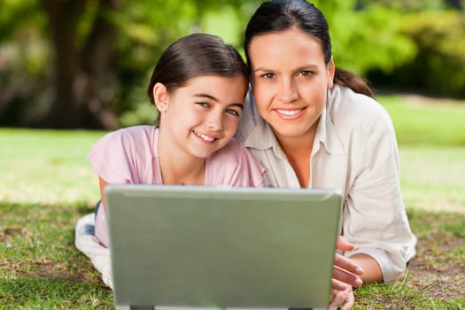 Mother and her daughter looking at their laptop during the summer