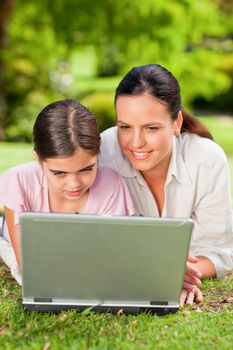 Mother and her daughter looking at their laptop during the summer