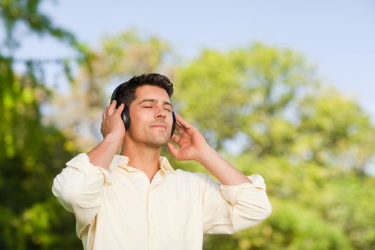 Man listening to music in the park during the summer 