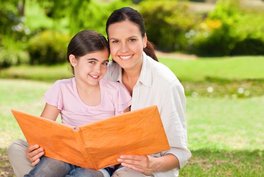 Daughter and her mother looking at their album photo during the summer 