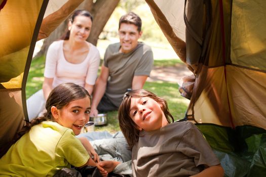 Happy family camping in the park during the summer