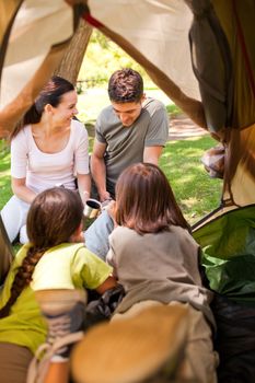 Happy family camping in the park during the summer