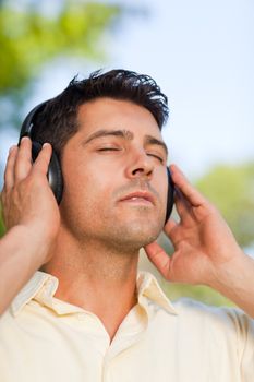 Man listening to music in the park during the summer 