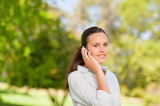 Woman phoning in the park during the summer