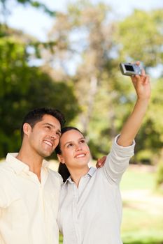 Young couple taking a photo of themselves in a park