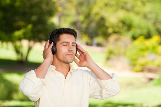 Man listening to music in the park during the summer 