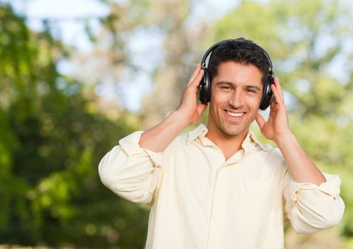 Man listening to music in the park during the summer 