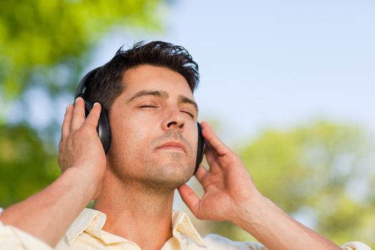 Man listening to music in the park during the summer 