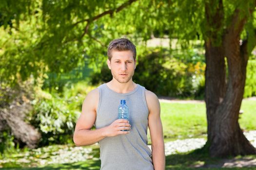 Sporty handsome man in the park during the summer