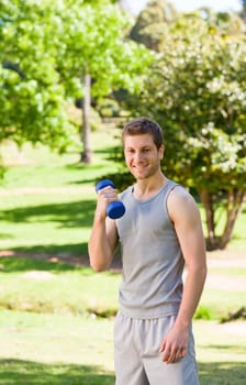 Young man doing his exercises in the park during the summer