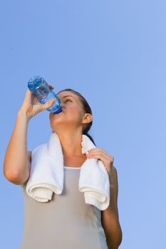 Young woman drinking water during the summer