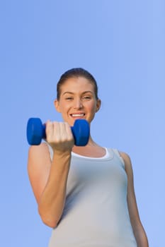 Young woman doing her exercises in the park during the summer