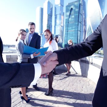 Business handshake, the deal Is finalized by group of people outside