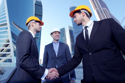 Investor and contractor shaking hands, view from below