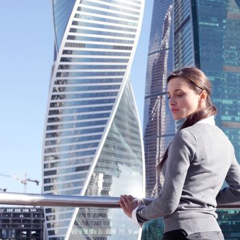 Young beautiful businesswoman outdoors at skyscraper background