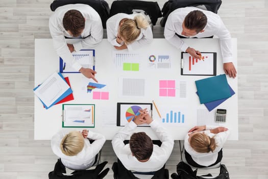 Business people work with statistics documents with tables and diagrams sitting around the table